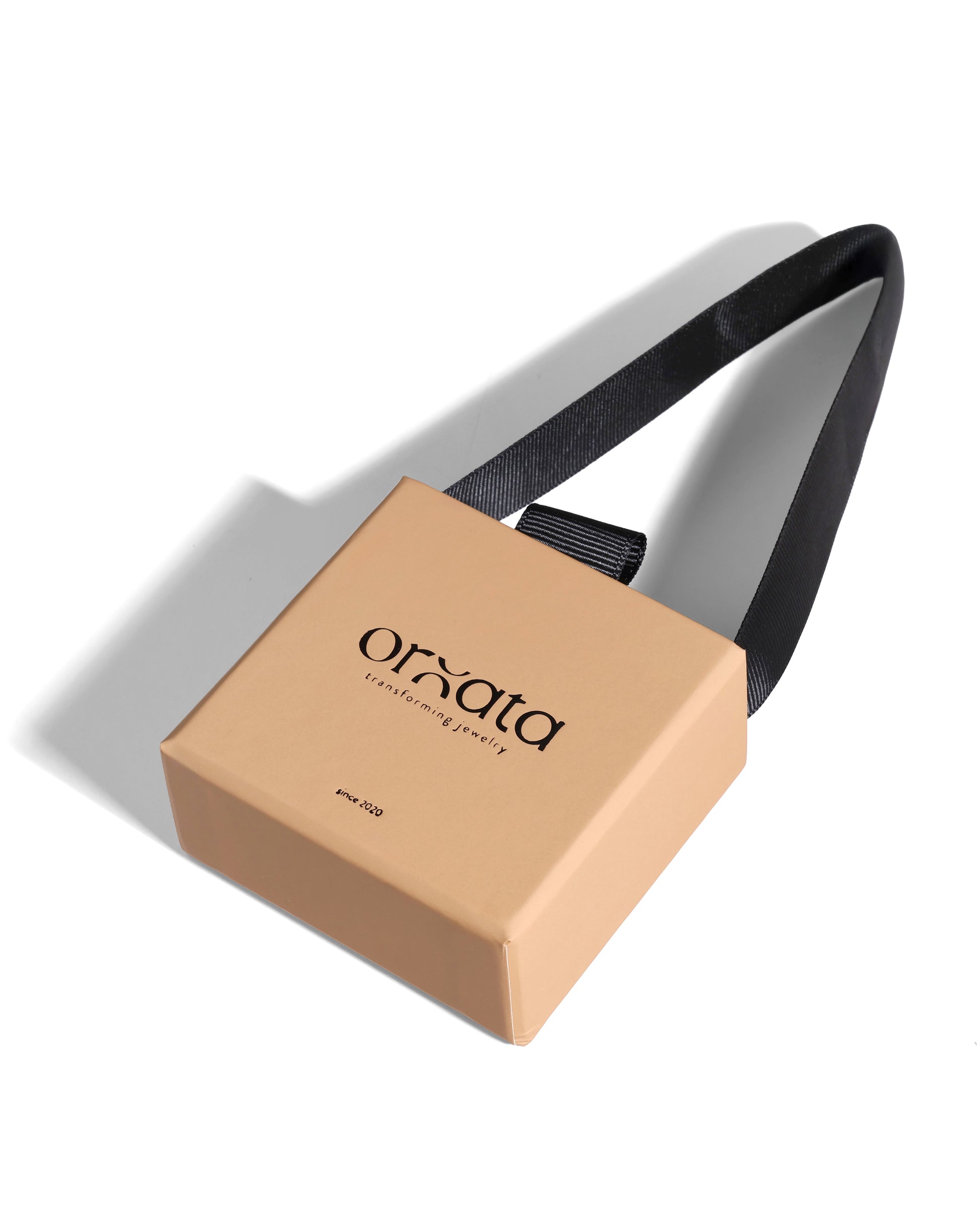 Beige jewelry box with black strap on a white background