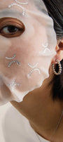 Close-up of a girl in a face mask and silver hoop earring