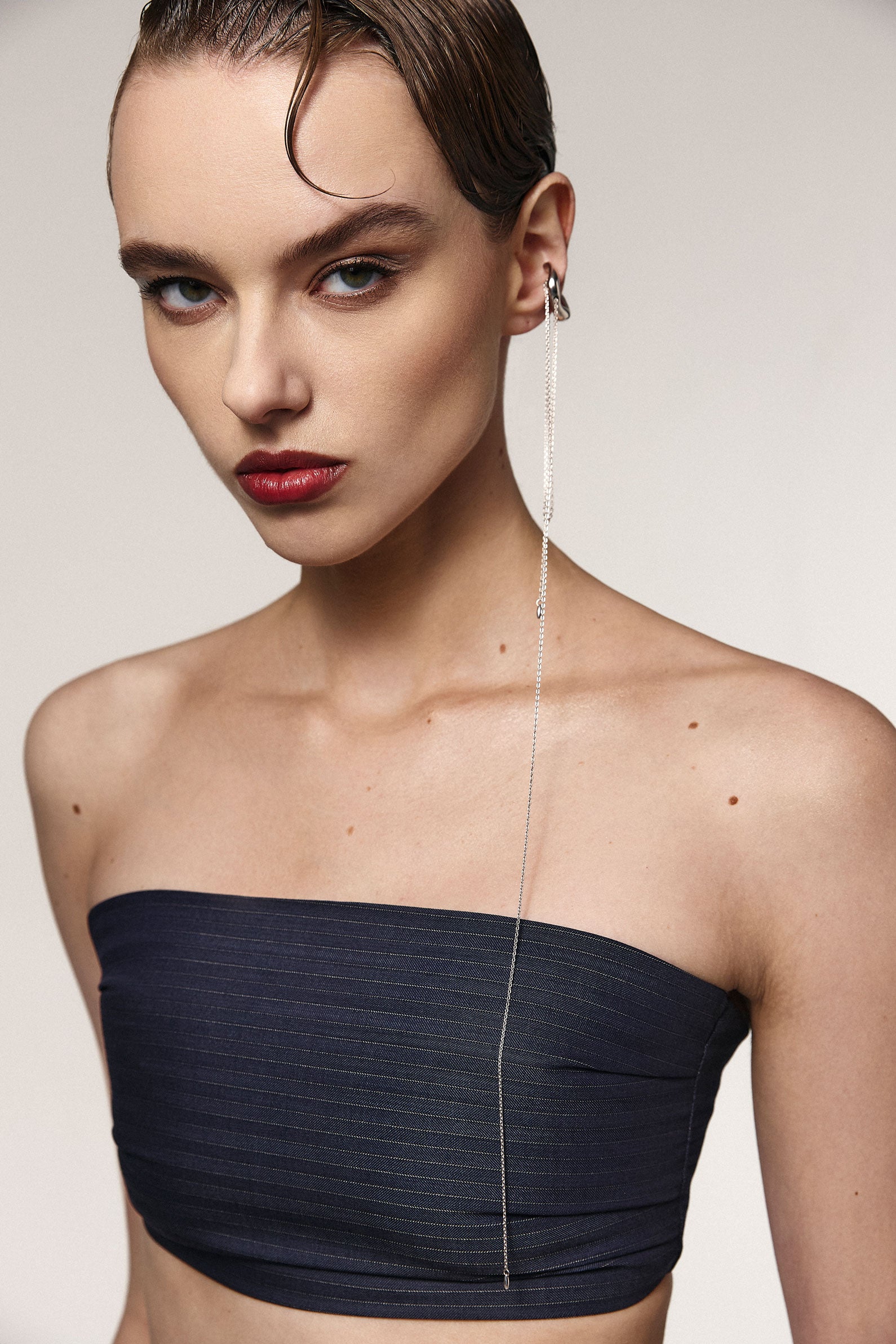 Woman wearing strapless top and silver Entero cuff-necklace on the ear