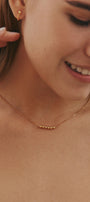 Close-up of a girl wearing a gold choker with movable beads