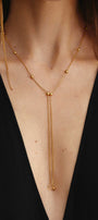 Gold necklace with small beads on a black top