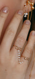 Hand wearing two gold rings with a cubic-zirconia connector