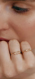 Close-up of a person's hand wearing two thin gold rings-transformers
