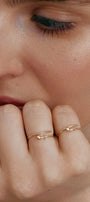 Close-up of a person's hand wearing two thin gold rings-transformers