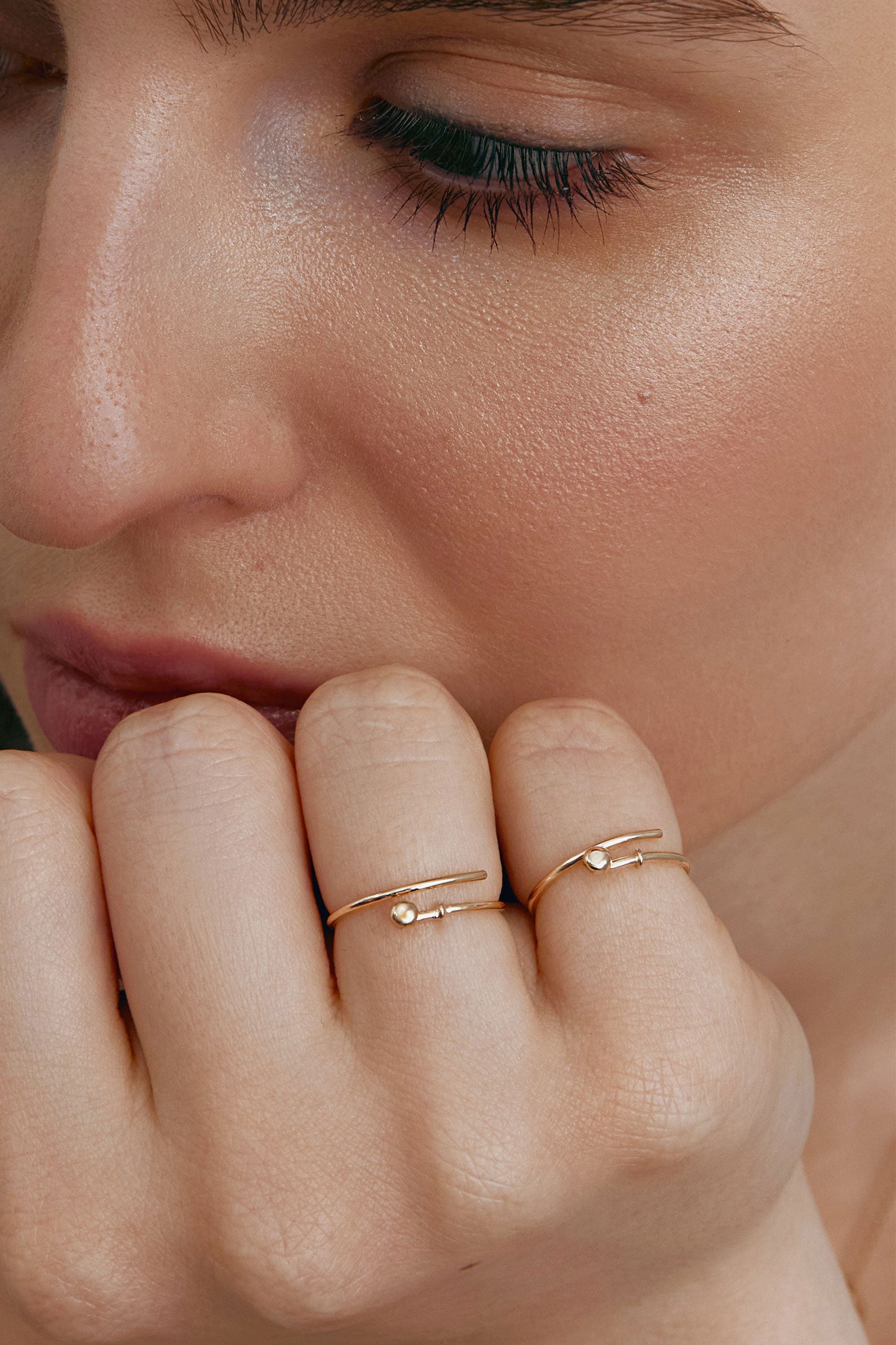 Close-up of a person's hand wearing two thin gold rings-transformers