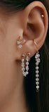 Close-up of an ear wearing gold modular jewelry with gems