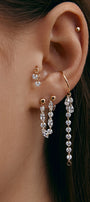 Close-up of an ear wearing gold modular jewelry with gems