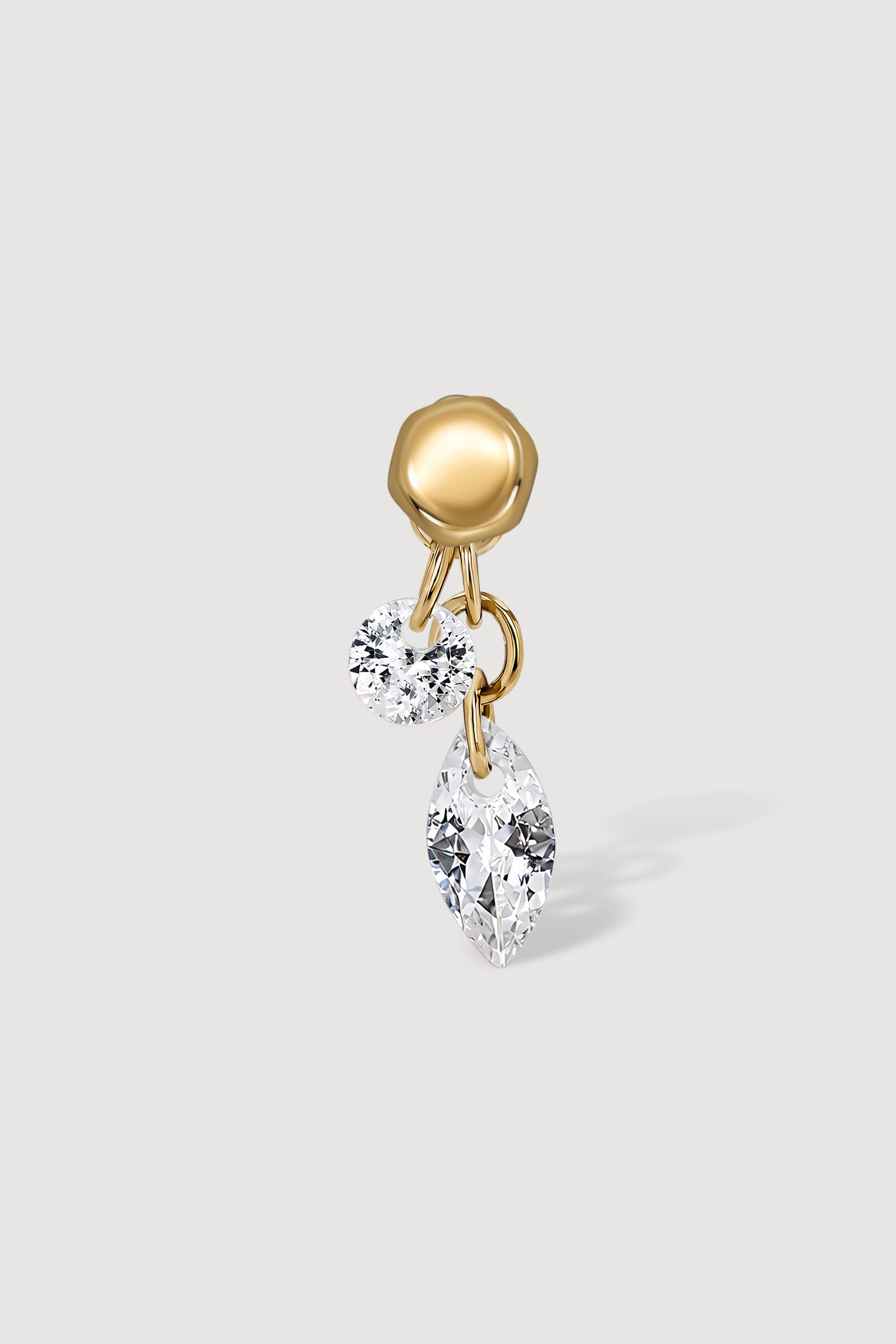 Gold earring with clear gemstones on a light gray background