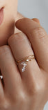 Close-up of a hand wearing a gold ring with a marquise cut gems