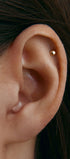 Close-up of an ear with a small gold stud earring