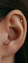 Close-up of an ear with a small gold stud earring