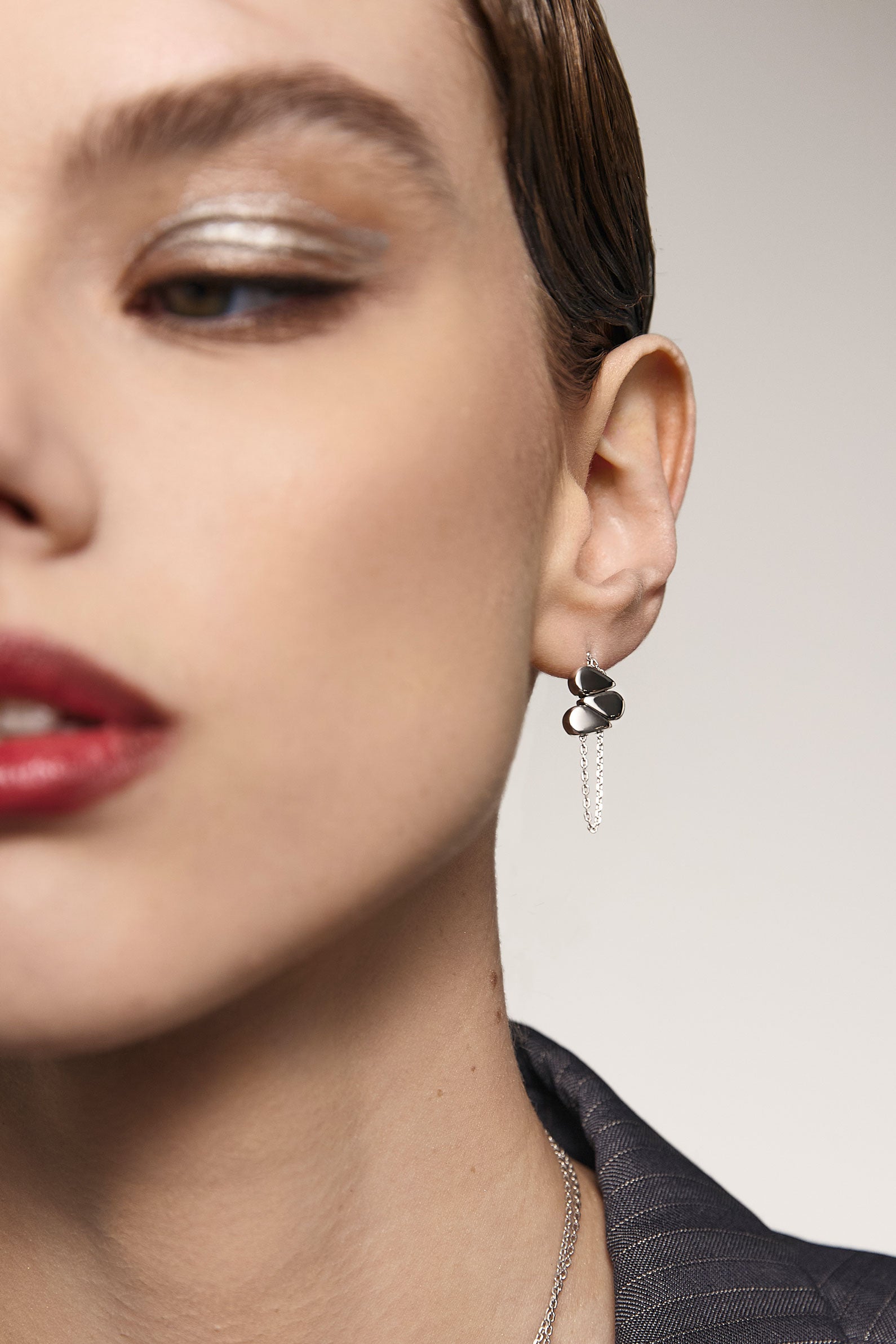 Close-up of a woman wearing an earring with movable sliders