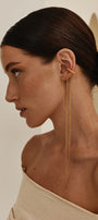 Woman wearing gold ear cuff with long asymmetric chains