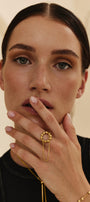 Woman wearing a gold 3-in-1 cuff-ring  against a beige background