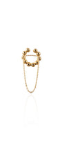 Gold cuff-ring with spherical design and chain on a white background
