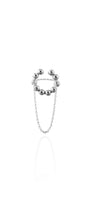 Silver beaded cuff-ring with chain on a white background