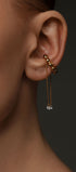 Gold ear cuff with chains and gems on the ear